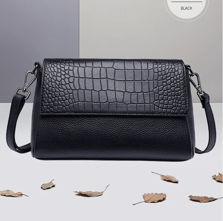 Sac bandoulière femme noir motif croco en cuir vegan, avec bandoulière réglable et détails dorés.