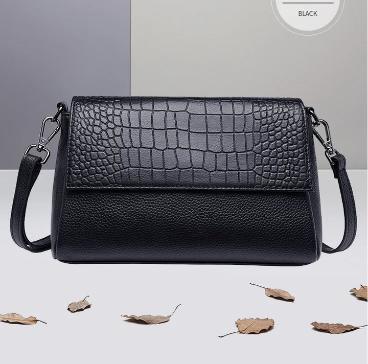 Sac bandoulière femme noir motif croco en cuir vegan, avec bandoulière réglable et détails dorés.