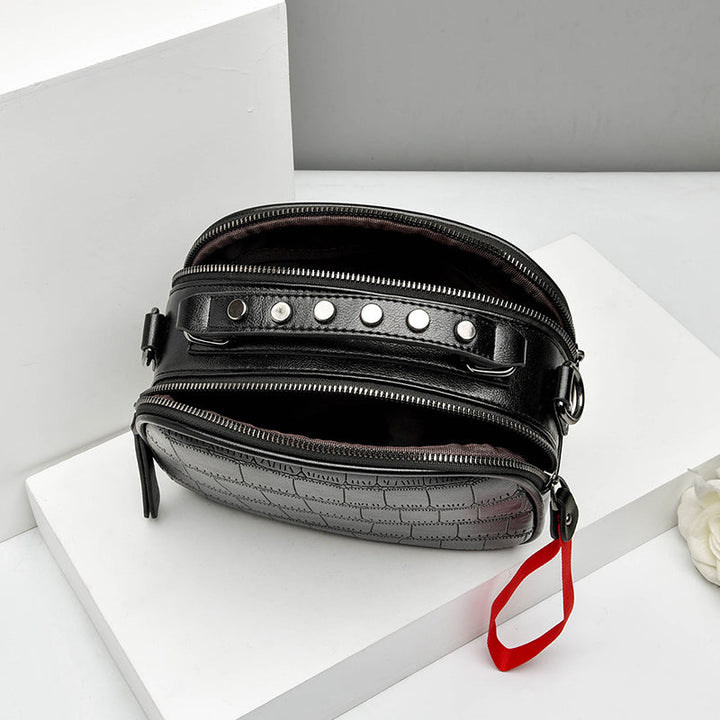 Gros plan sac bandoulière noir croco, finitions soignées, matière cuir synthétique, chic