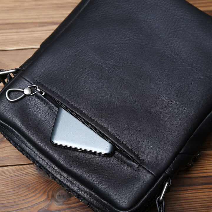 Vue arrière du sac bandoulière homme Aaron en cuir noir, soulignant le design global de cet accessoire.