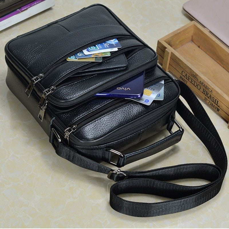 Détail de la boucle métallique et des finitions soignées sur un sac bandoulière homme en cuir