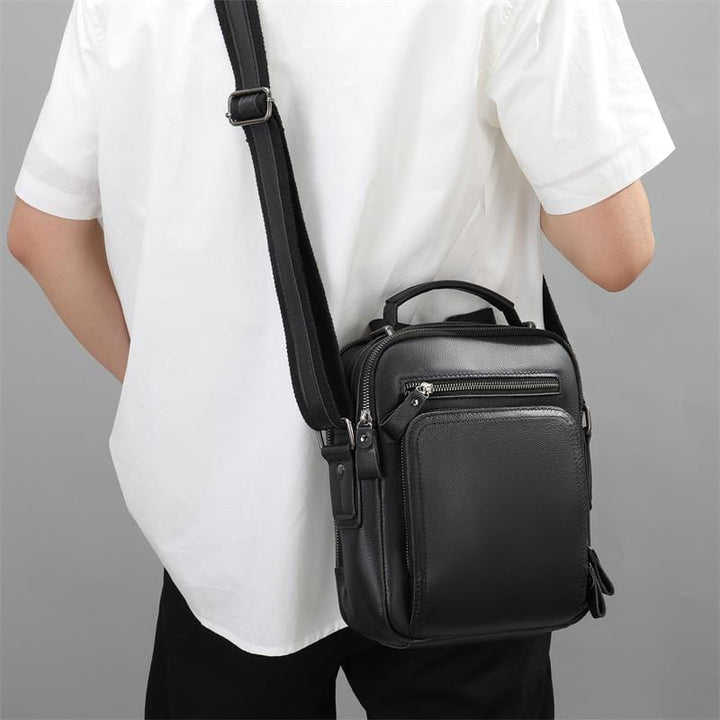 Sac cuir homme noir, doté d'une poignée supérieure en plus de la bandoulière amovible.