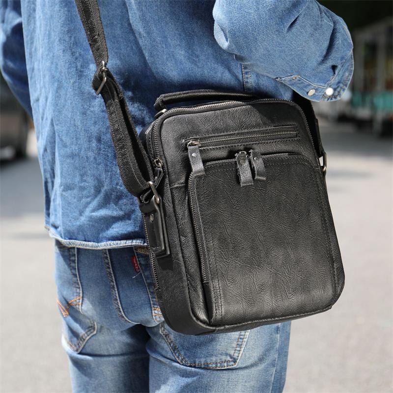 Accessoire homme: sac bandoulière en cuir lisse, parfait pour un look moderne et raffiné.