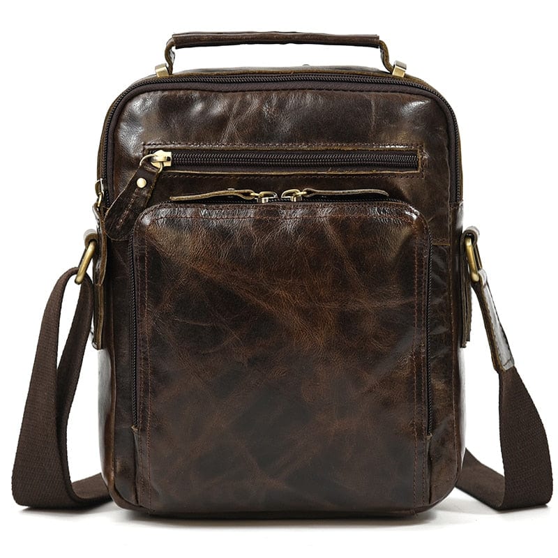 Maroquinerie homme: sac bandoulière en cuir noir avec boucles métalliques décoratives.