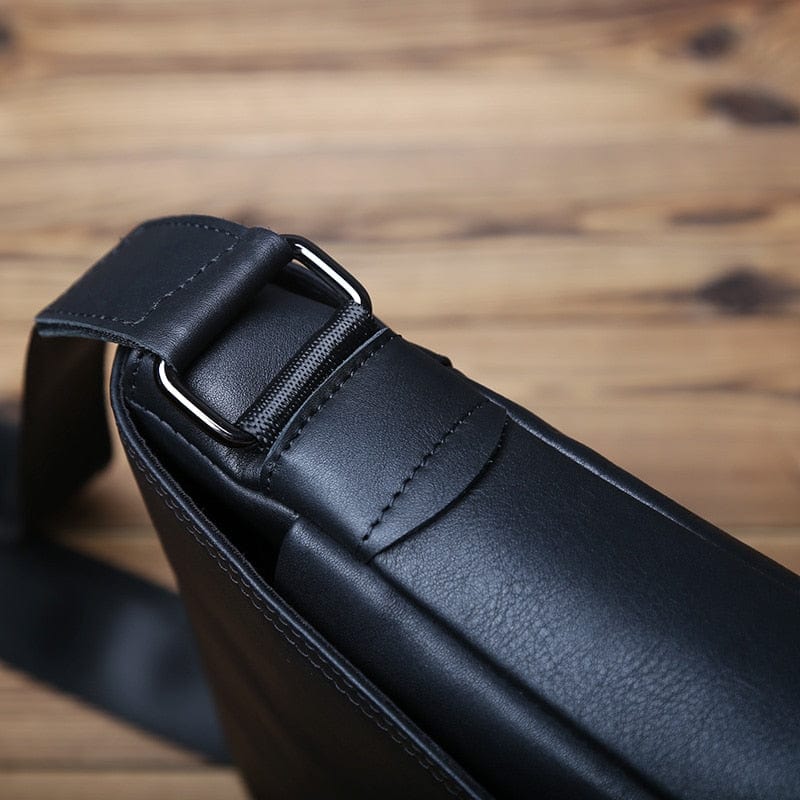 Vue de face d'un sac bandoulière homme en cuir noir, fermetures éclair apparentes, poche extérieure