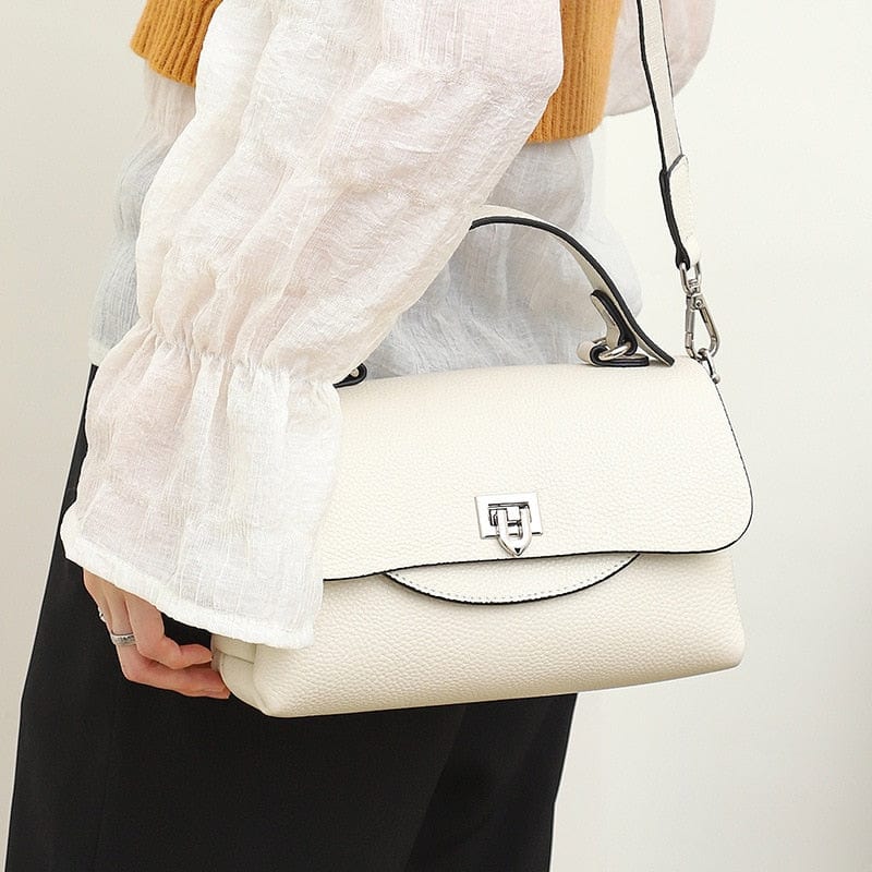 Sac femme en cuir grainé bleu marine, doté d'une longue bandoulière et d'une fermeture sécurisée.