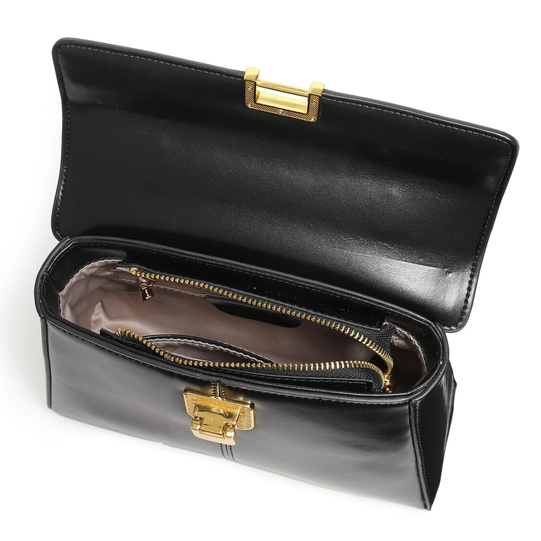 Sac bandoulière en cuir noir posé sur une surface neutre, mettant en valeur son design épuré.