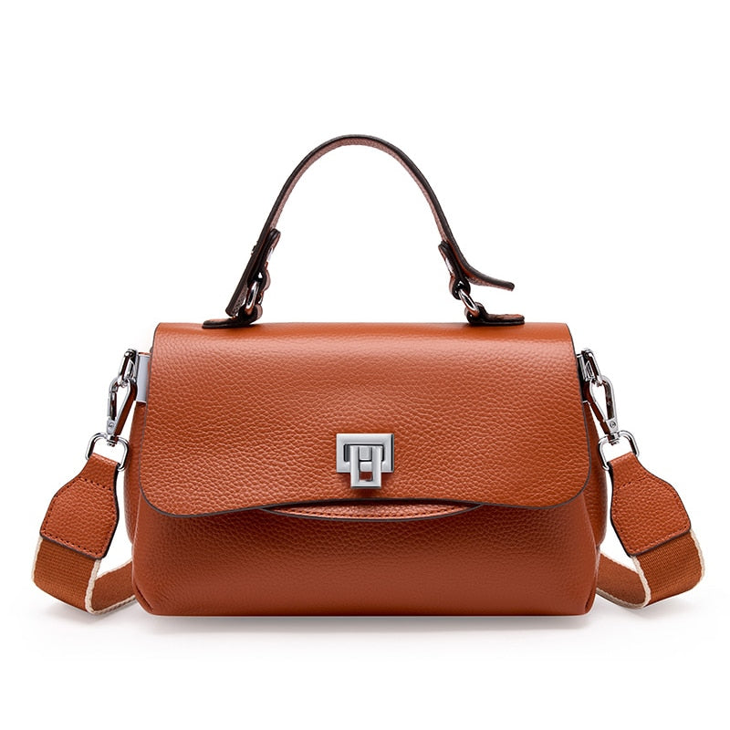 Gros plan sur le sac bandoulière en cuir véritable bleu, montrant la texture raffinée et les détails de qualité.