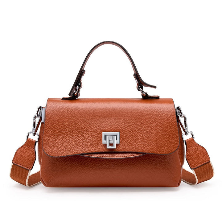 Gros plan sur le sac bandoulière en cuir véritable bleu, montrant la texture raffinée et les détails de qualité.