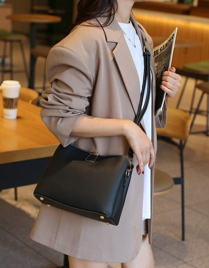 Détail de la base renforcée d'un sac à main en cuir véritable, protégeant l'accessoire mode. Durabilité assurée.