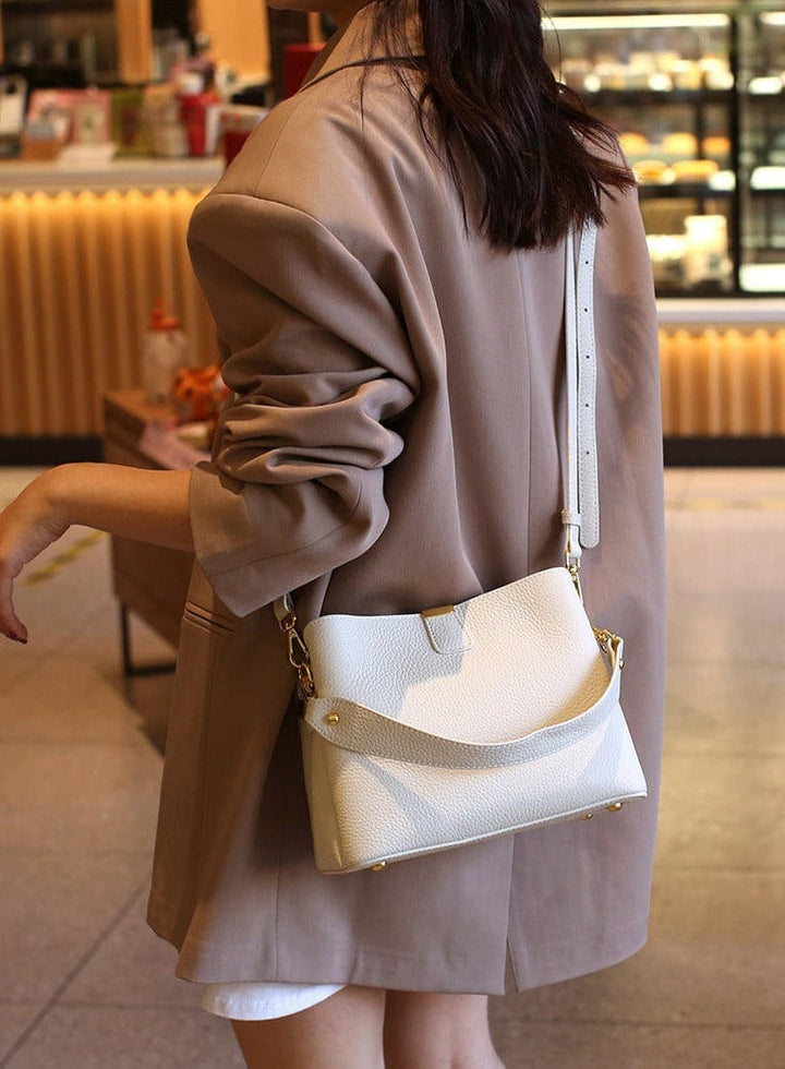 Sac à main élégant en cuir véritable, sur un fond texturé. Mettant en valeur la riche texture du cuir.