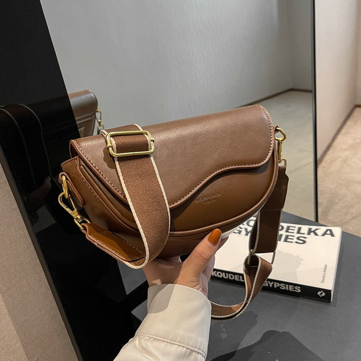 Femme élégante portant un sac bandoulière moderne en cuir PU, parfait pour un look quotidien chic.