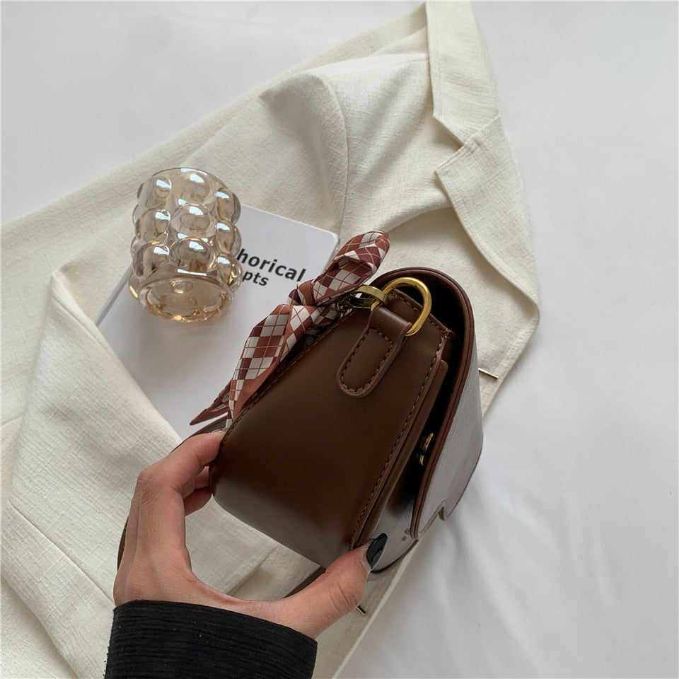 Sac bandoulière femme polyvalent porté de côté, idéal pour accessoiriser une tenue mode urbaine.