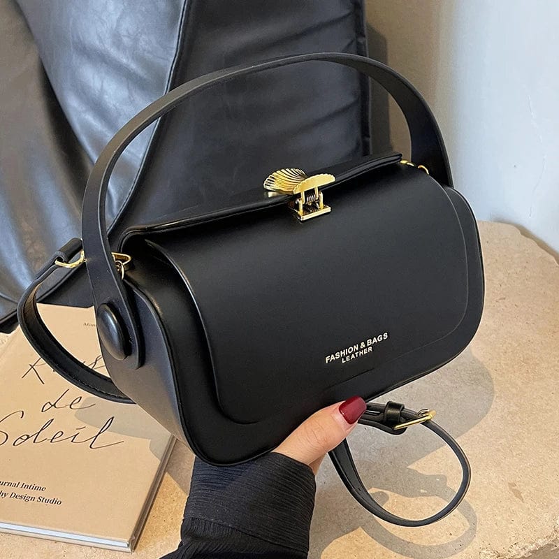Détail du fermoir doré sur un sac à main bandoulière femme en cuir PU noir.