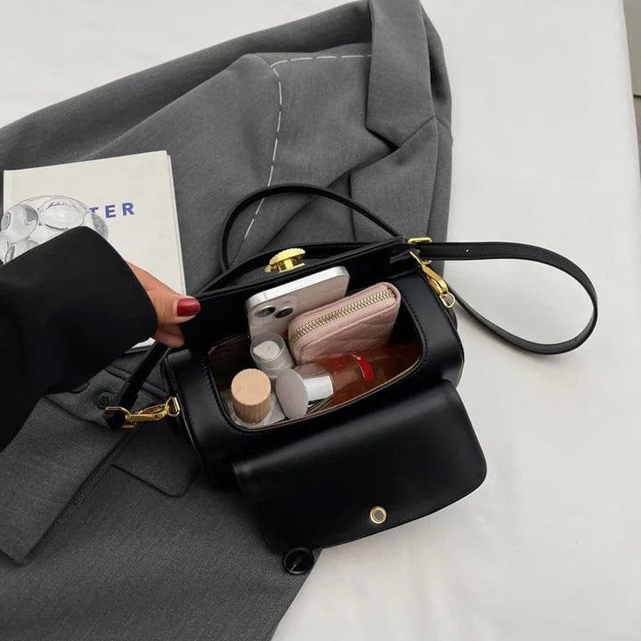 Sac à main femme porté sur l'épaule, mettant en valeur son design élégant et sa couleur noire.