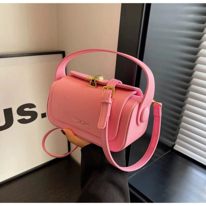 Sac à main femme beige posé sur une table en bois, accessoire de mode discret.