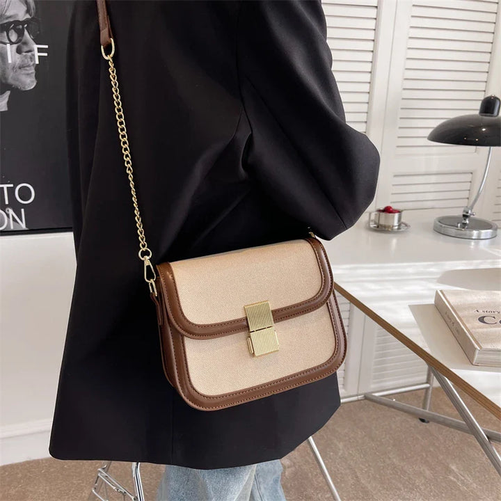 Sac bandoulière élégant en toile et cuir, posé sur une surface en bois, mettant en valeur sa texture, sac femme