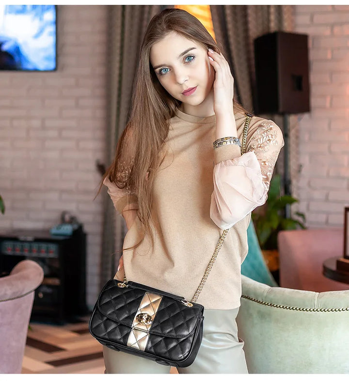 Sac à main femme en cuir noir matelassé avec bandoulière chaîne dorée. Accessoire de mode pratique et sophistiqué.