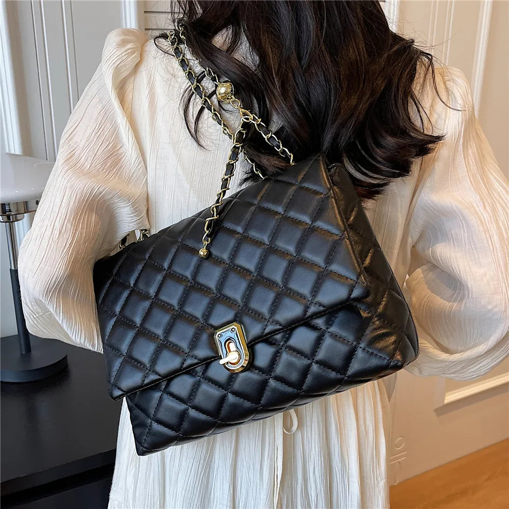 Sac bandoulière matelassé noir élégant en cuir synthétique pour femme, style mode, vue de face.