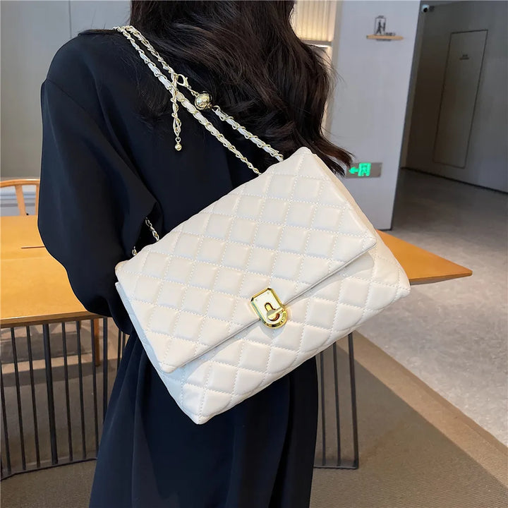 Sac bandoulière matelassé noir, vue de dos, montrant la pochette zippée extérieure pour femme.
