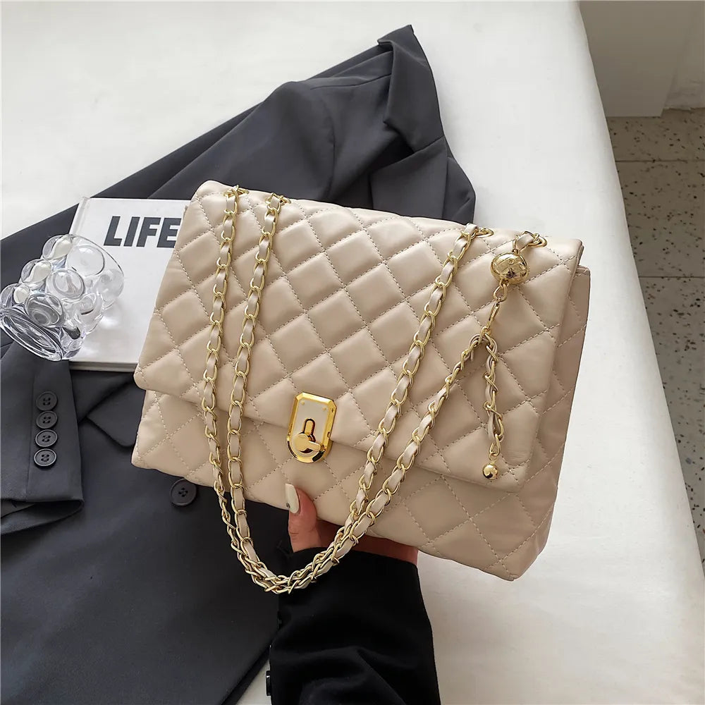 Accessoire de mode: sac bandoulière matelassé synthétique avec rabat et fermoir magnétique pour femme.