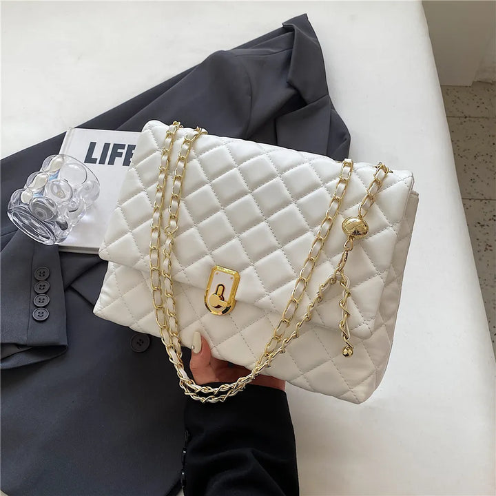 Sac bandoulière matelassé noir élégant ouvert révélant l'intérieur spacieux pour femme.
