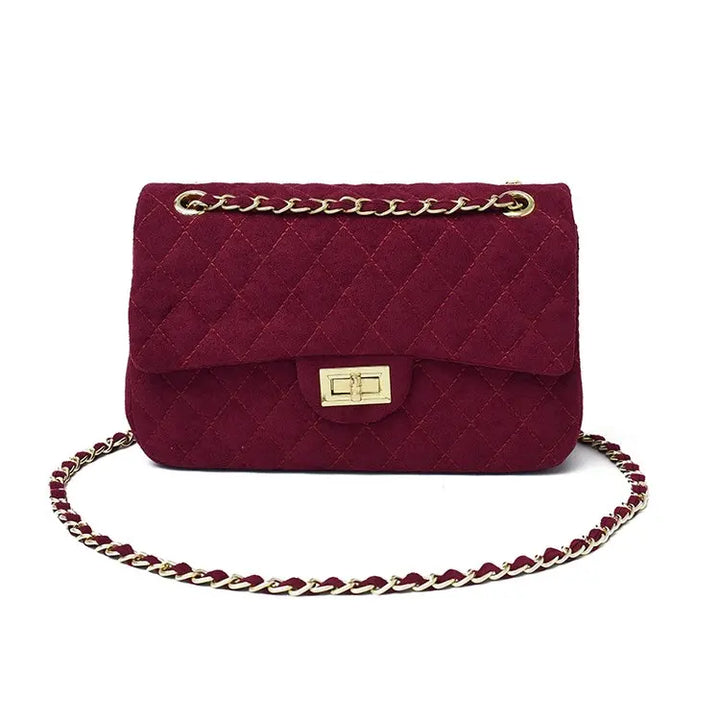 Sac femme matelassé avec chaîne, porté épaule. Sac bandoulière chic, accessoire mode essentiel.