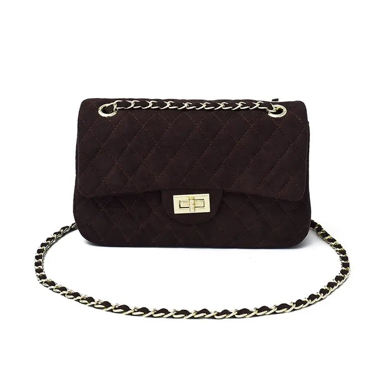 Femme portant élégamment un sac bandoulière matelassé à chaîne. Accessoire mode chic, sac épaule quotidien.