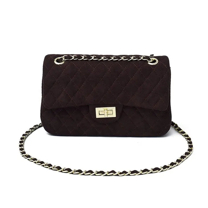 Femme portant élégamment un sac bandoulière matelassé à chaîne. Accessoire mode chic, sac épaule quotidien.
