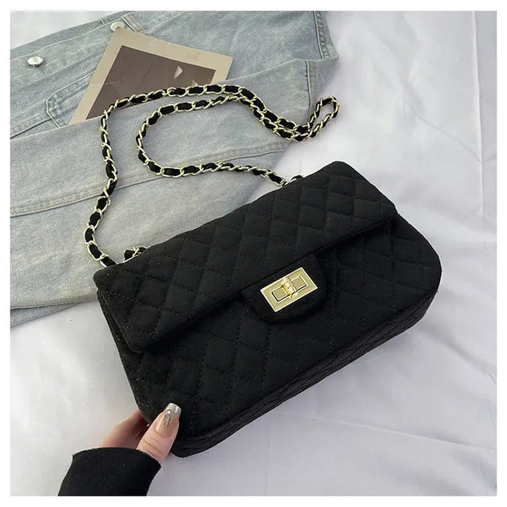 Détail du fermoir et de la chaîne sur un sac bandoulière matelassé pour femme. Sac chic et fonctionnel.