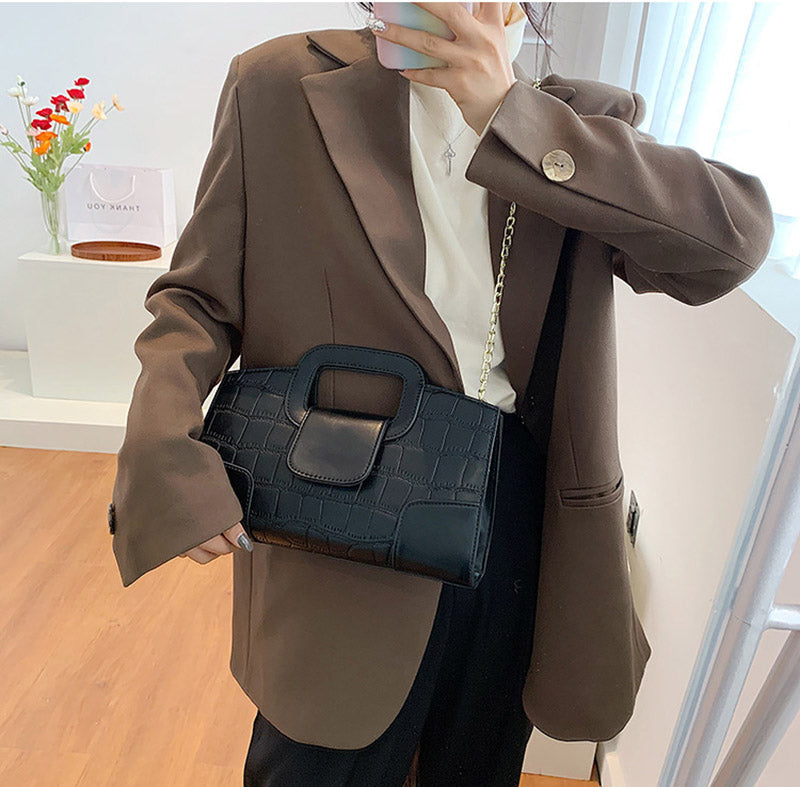 Sac à bandoulière noir en cuir synthétique, détails de chaîne dorée, polyvalent et très chic pour femme.
