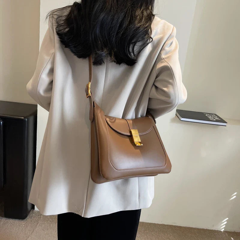Détail de la bandoulière réglable d'un sac noir, en cuir synthétique, chic et confortable.