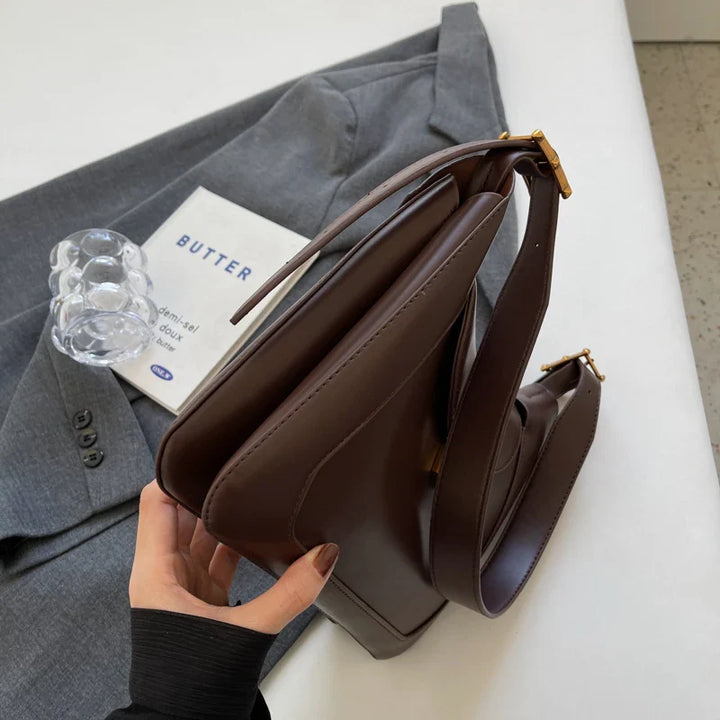 Sac à bandoulière noir chic pour femme, avec fermeture sécurisée, un accessoire de mode essentiel.
