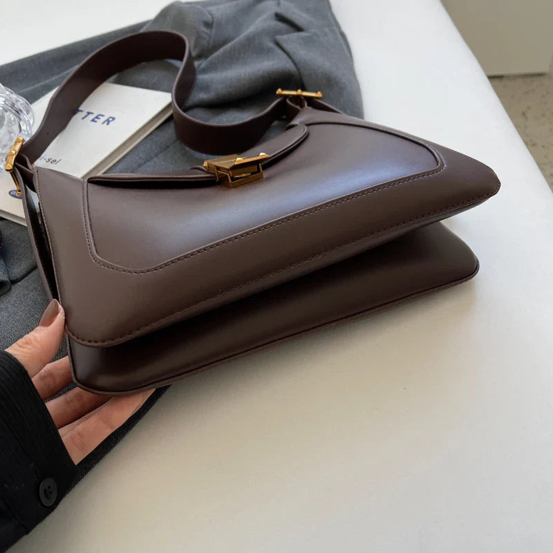 Sac bandoulière femme noir et marron, présentant des dimensions pratiques et un look très mode.