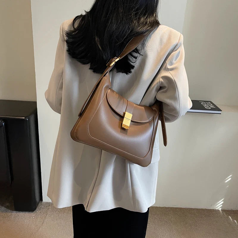 Sac bandoulière tendance noir pour femme, détail doré, parfait pour toute occasion.