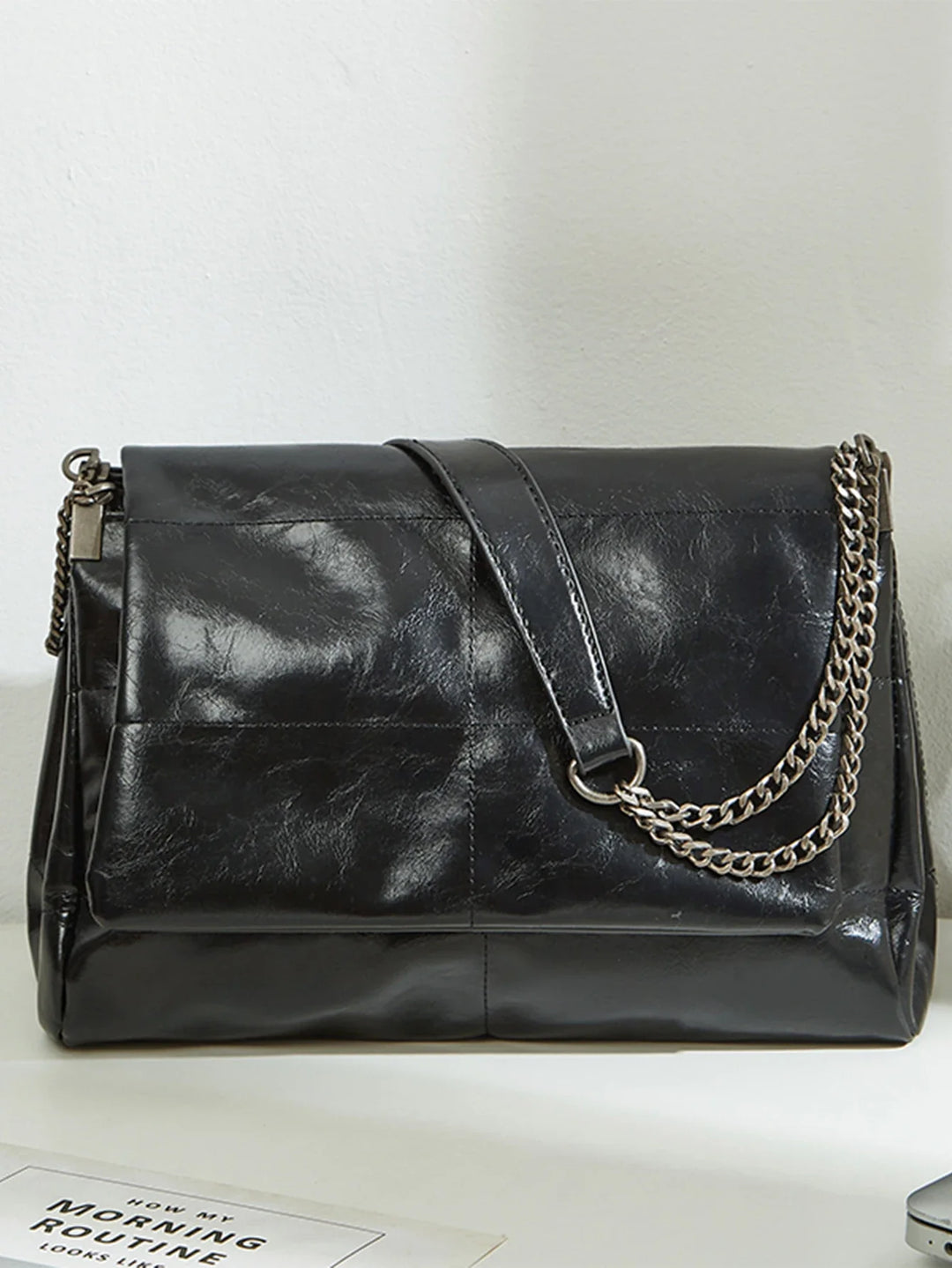Sac à épaule femme chic noir en similicuir, bandoulière réglable, accessoire de mode urbain.