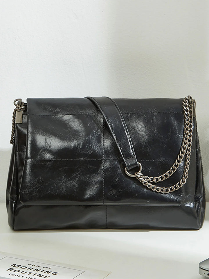 Sac à épaule femme chic noir en similicuir, bandoulière réglable, accessoire de mode urbain.
