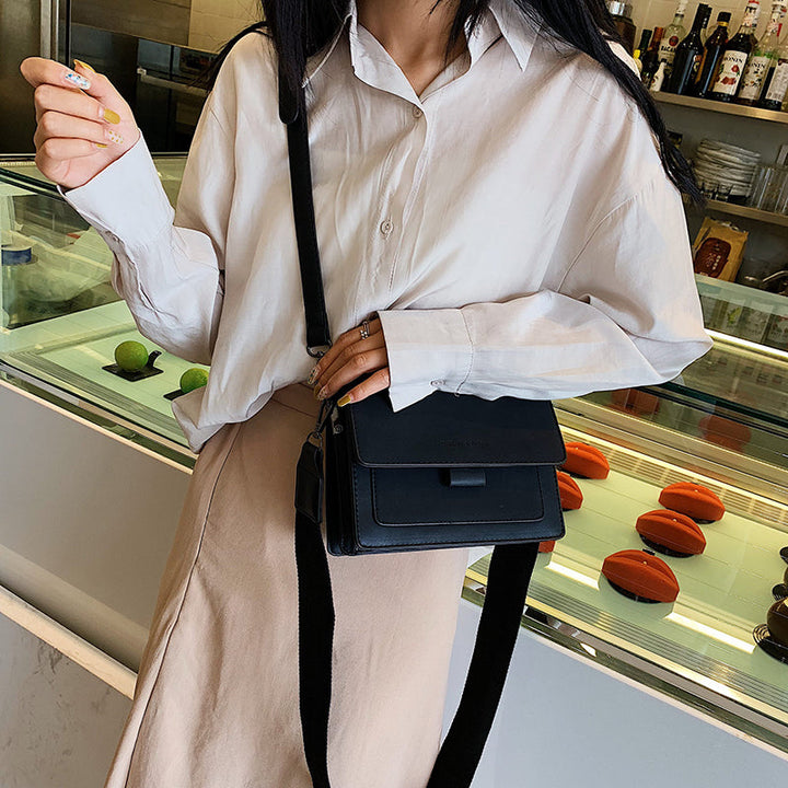 Sac bandoulière élégant noir pour femme, grand compartiment, fermeture sécurisée, accessoire mode pratique.