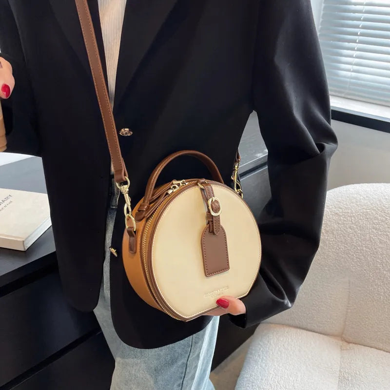Sac bandoulière rond élégant en cuir marron, parfait pour femme stylée.