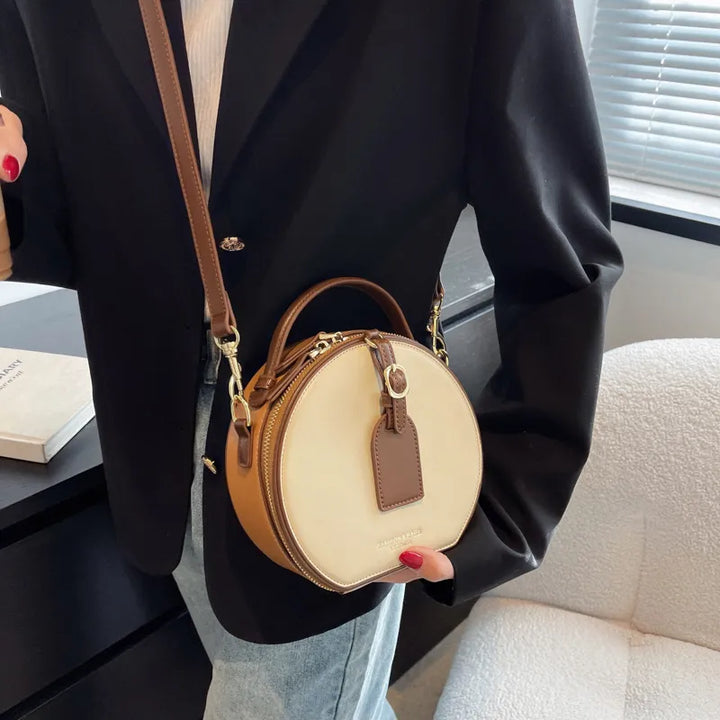 Sac bandoulière rond élégant en cuir marron, parfait pour femme stylée.
