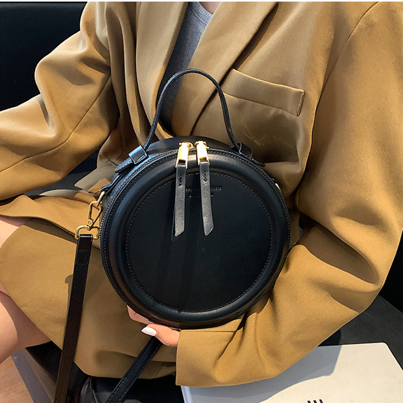 Élégant sac bandoulière rond noir pour femme, grand compartiment, sangle réglable, idéal pour sorties.