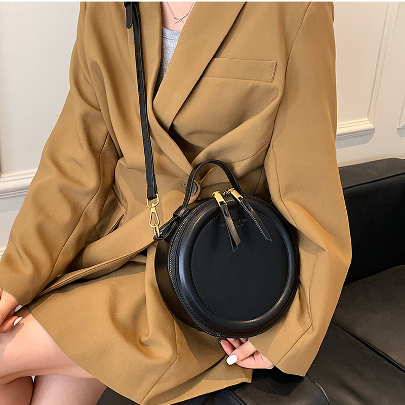 Accessoire de mode: sac à bandoulière rond noir en cuir synthétique, polyvalent, style chic et intemporel.