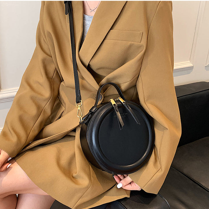 Accessoire de mode: sac à bandoulière rond noir en cuir synthétique, polyvalent, style chic et intemporel.