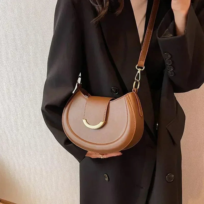 Maroquinerie fine: sac bandoulière rond en similicuir grainé, parfait pour toutes occasions.