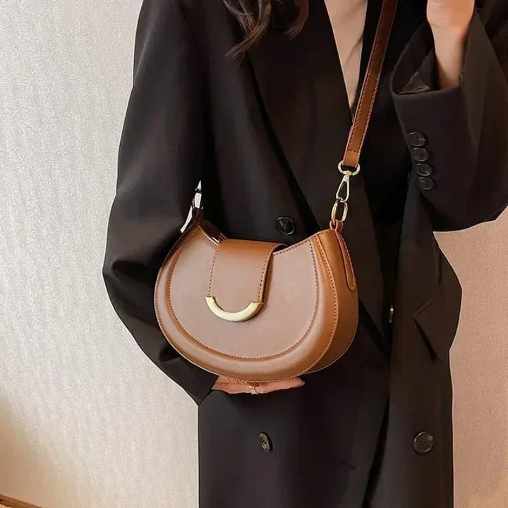 Maroquinerie fine: sac bandoulière rond en similicuir grainé, parfait pour toutes occasions.