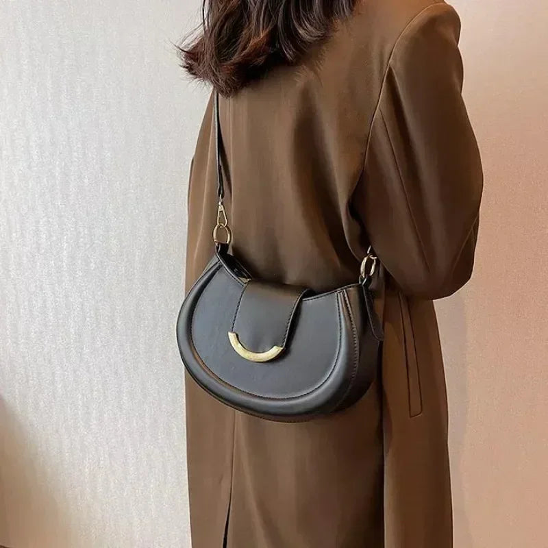 Sac polyvalent rond noir pour femme, doté d'une fermeture éclair sécurisée et intérieur spacieux.