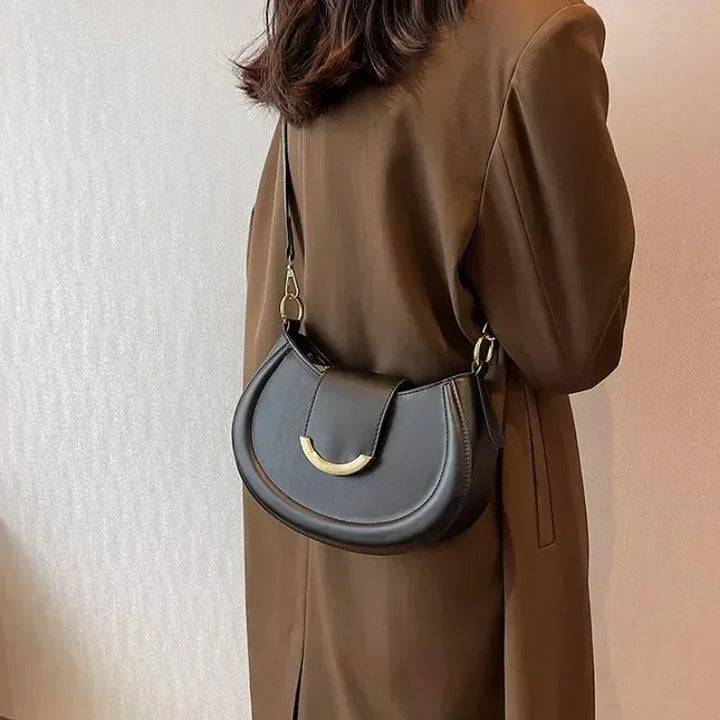 Sac polyvalent rond noir pour femme, doté d'une fermeture éclair sécurisée et intérieur spacieux.