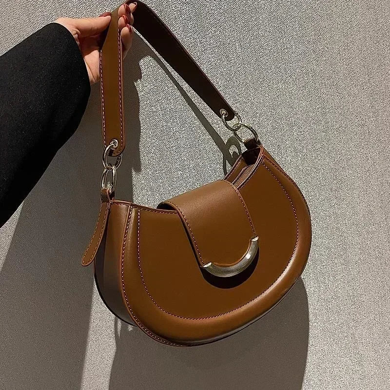 Vue détaillée d'un sac bandoulière rond chic, avec quincaillerie dorée, accessoire incontournable.