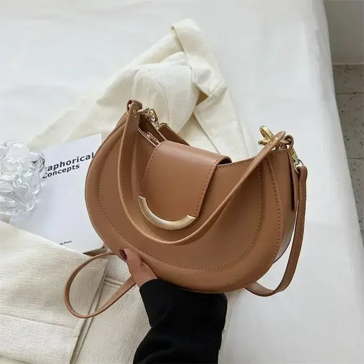Image de près du fermoir d'un sac rond élégant, présentant des détails soignés et du style.