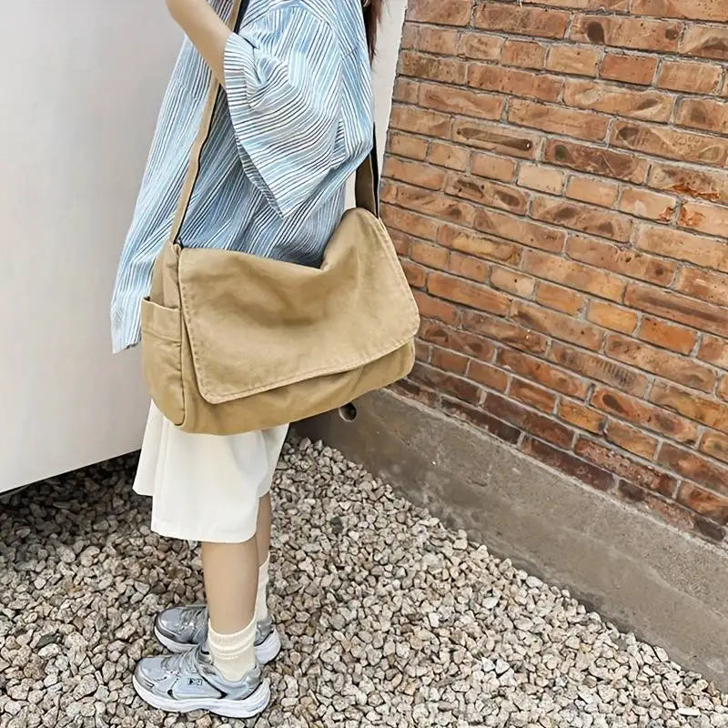 Personne portant un sac bandoulière unisexe en tissu écologique, accessoire de mode pour la ville.